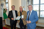 LH Christopher Drexler (l.) und Anton Lang (r.) mit Henry Sams, der das Goldene Ehrenzeichen des Landes Steiermark überreicht bekam.