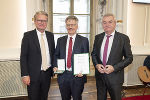 LH Christopher Drexler (l.) und LH-Stv. Anton Lang (r.) überreichten das Große Ehrenzeichen des Landes Steiermark an Werner Zenz